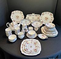 Full set arranged on table, showing all plates, cups, saucers, serving pieces