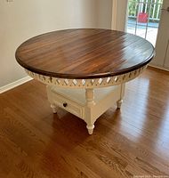 Front view of assembled round table showing cherry top and white painted lattice apron