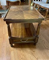 Front view of the Drexel Italian series wood end table showing the drawer and turned legs.