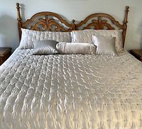 Full view of wood headboard installed on king size bed with bedding and pillows for scale.