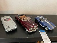 Photo of all three model cars on a black shelf showing the Mercedes 300 SLR, 1947 Cadillac, and Shelby Cobra 427 S/C models for scale and color