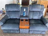 Front view of loveseat upright with closed console showing wood top and two cupholders