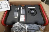 Top-down view of new generator’s black fuel tank and red frame with sealed accessories