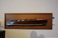 Full frontal view of the wooden boat model mounted on a wooden frame showing the profile and hull of the Chris Craft Runabout half model.