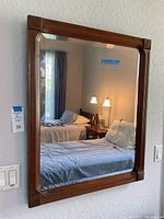 Front view of mirror hanging on textured wall in guest bedroom