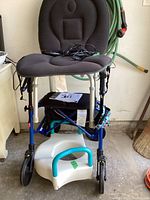 Nexus rollator walker with black padded backrest and seat, folded, showing larger front wheels and frame