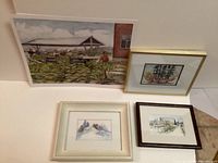 Four framed watercolor paintings by Nellie Vangastel showing various rural and nature scenes.