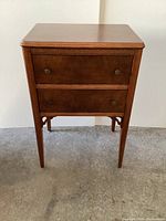 Front view of solid wood side table showing two drawers and legs