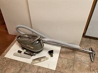 Full view of the vintage Tristar vacuum with hose and all attachments laid out.