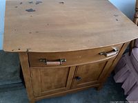 Full view of wash stand showing the top surface, drawer, and cabinet doors, highlighting wear on edges.