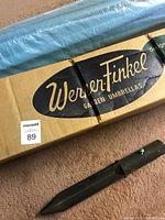 Photo of original WernerFinkle branded box and wrapped teal umbrella showing condition and packaging.