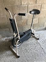 Full side view of the vintage CCM exercise bike showing frame, seat, pedals and flywheel assembly.