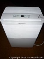 Front view of upright white Hisense dehumidifier on carpet