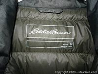 Close-up photo of inside jacket label showing brand Eddie Bauer, men's medium, made in China.