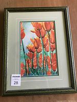 Framed watercolour painting shows vertical composition of vivid red tulips with green stems on a soft blue background, fully matted and framed.