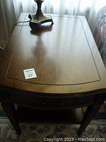 Top view showing smooth walnut finish and inlaid border detail on rectangular end table surface with gently curved edges.