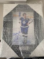 Bubble-wrapped octagonal framed photograph of Darryl Sittler in Maple Leafs uniform with signature visible