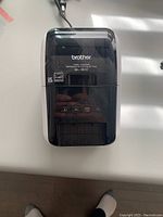 Front view of Brother GL-800 label printer showing control buttons and logo.