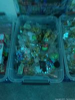A plastic container filled with assorted Pokémon figures and collectibles including various characters.