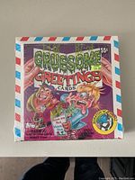 Photo shows a sealed original box of Gruesome Greetings trading cards with colorful cartoon horror-themed artwork and retail price 55 cents.