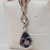 Close-up front view of pendant showing pear-shaped tanzanite and diamond detail