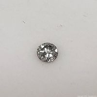 Close-up image of loose salt and pepper diamond on white background showing facets and inclusions.