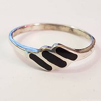 Close-up front angle showing black onyx inlays and silver band.