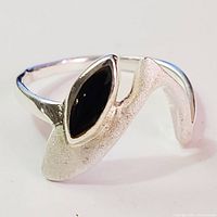 Close-up front view of the silver ring showing the marquise black onyx stone and textured silver design.