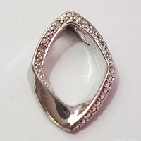 Close-up of the silver pendant showing diamond detailing.