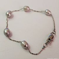 Full view of the silver freshwater pearl bracelet showing the pearl spacing, chain detail, and lobster clasp.