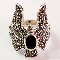Front view of silver ring with black onyx centerpiece and marcasite detailing forming wing-like shapes