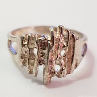 Front view of silver ring showing textured abstract vertical bar design
