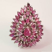 Top view showing the cluster of marquise and pear-shaped rubies arranged fan-like on silver ring.