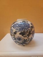 Front view of oval ceramic vase showing blue floral design on white background