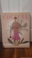 Front view of Couture June 1955 print showing a woman in pink dress and floral background