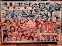 Front cover of the Coronation Street puzzle box featuring a collage of faces of characters from the show, with the title and 35th anniversary emblem