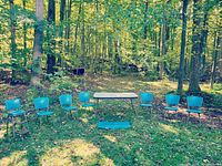 Photo of full set outdoors showing six blue vinyl chairs, rectangular table, step stool, and vinyl fabric piece on ground