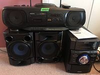 Full view of Sanyo boombox portable radio with CD and cassette player, and Sony mini Hi-Fi stereo receiver with two speakers.