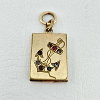 Front view of rectangular 14K gold locket with anchor motif set with synthetic stones