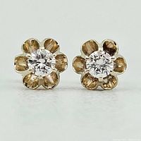 Front view of both earrings showing floral claw settings with diamonds