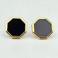Front view of two octagonal gold cufflinks with black onyx inlays on white background