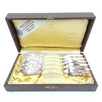 Five ornate silver forks in original hinged box with yellow satin lining