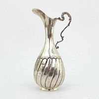 Front view of silver jug showing overall shape and ribbed pattern