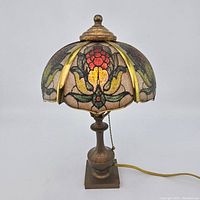 Full side view of the antique Pairpoint lamp with stained glass shade and brass base