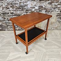 Full view of teak bar cart showing top surface, lower shelf and casters.