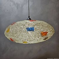Side view of the oval resin-coated acrylic fiber shade showing multicolored flecks