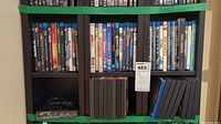 Photo showing two rows of DVDs on dark wood shelf, including Harry Potter set and various Blu-rays and DVDs.
