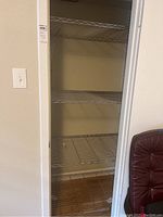 Full view of the metal storage rack installed in a closet space.