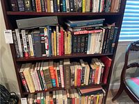 Two shelves filled with a wide range of books in both hardback and paperback formats. Includes various literary and reference books.