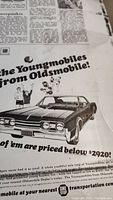 Close-up photo of aluminum plate showing Oldsmobile car advertisement from 1967 with headline 'Youngmobiles from Oldsmobile'